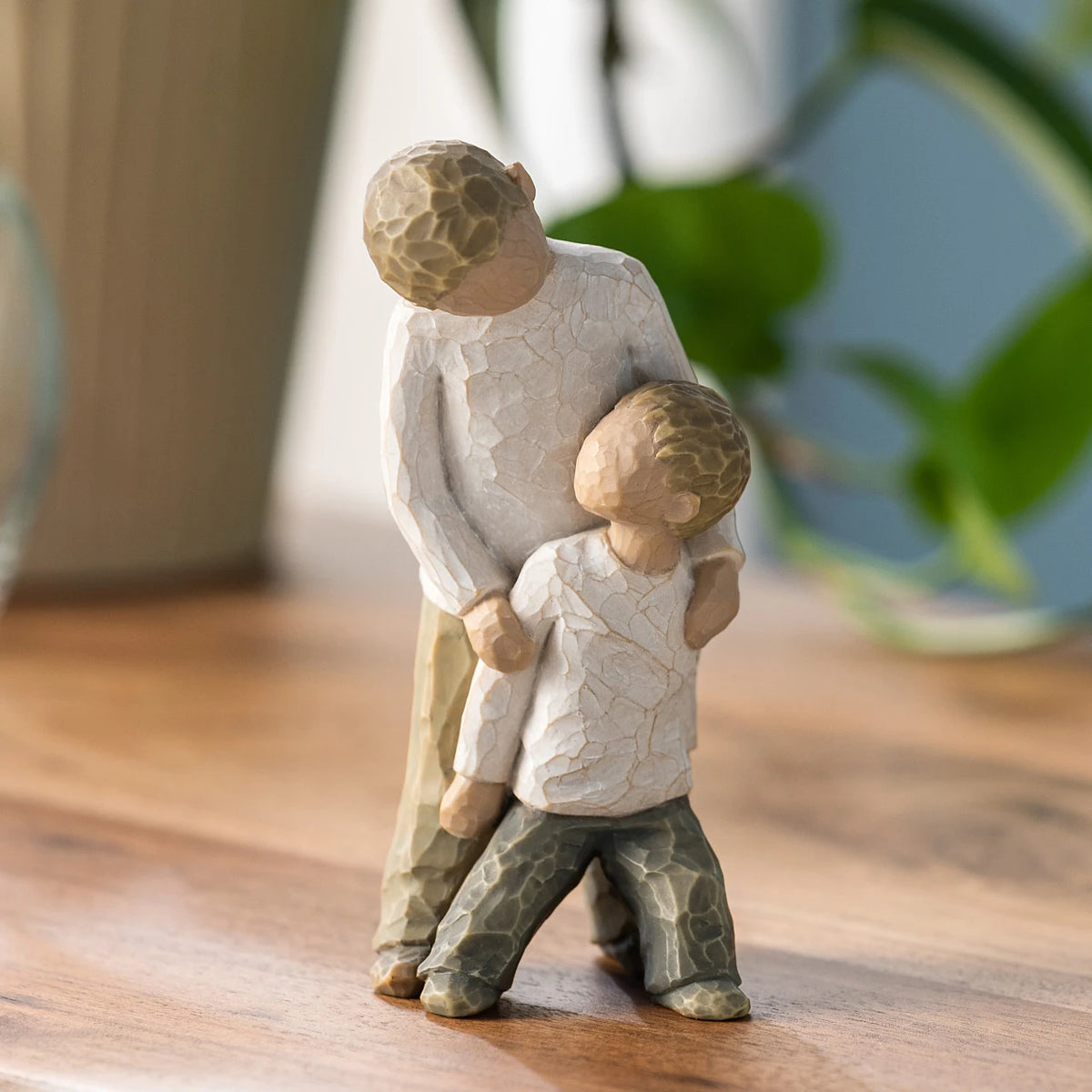 Willow Tree Brothers, 5"h hand-painted resin figure of two boys, younger leaning against older, both dressed in neutral colors, on wooden table