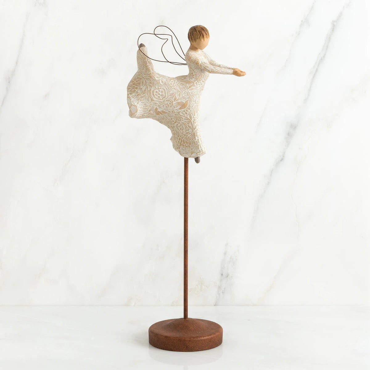 Faceless angel figurine wearing all white dress dancing on wooden pedestal stand