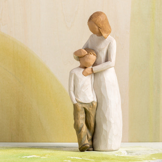 Willow Tree Mother and Son, 8”h hand-painted standing resin figure with arms around young boy, both in neutral clothing, in front of ochre painting