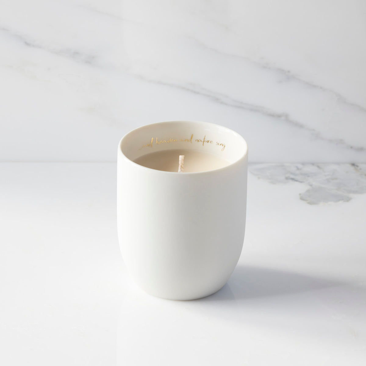 Filled scented candle with unglazed off-white tapered cylinder vessel, sentiment written in gold inside rim, plant-based wax blend, all-cotton wick.