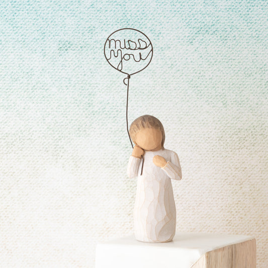 Willow Tree Miss You, 5”h hand-painted standing resin figure in cream dress holding wire ballon with words 'miss you' written in wire, in front of light aqua painting
