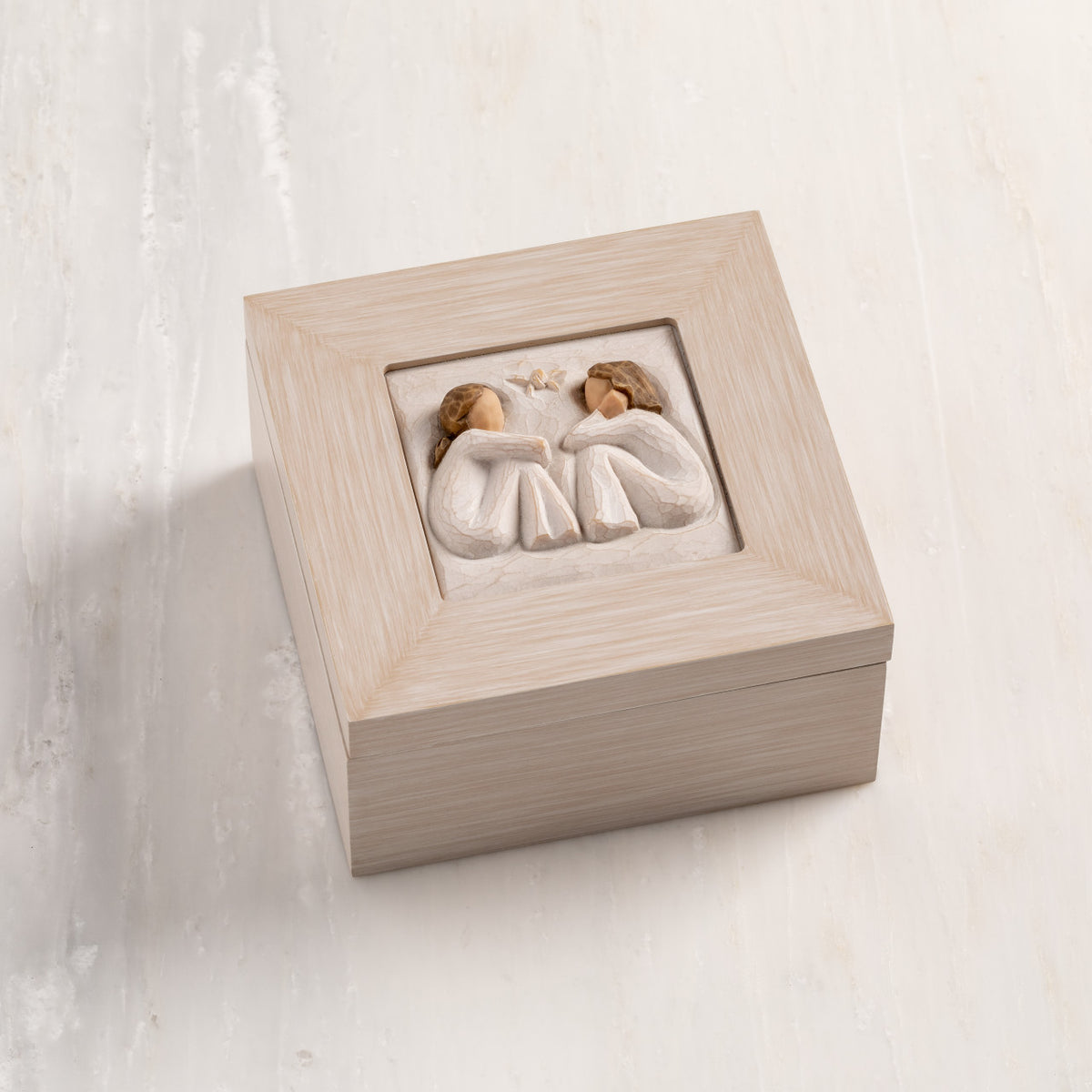 Cream wood box with hinged lid. Inset bas-relief plaque of two seated girls, facing each other.