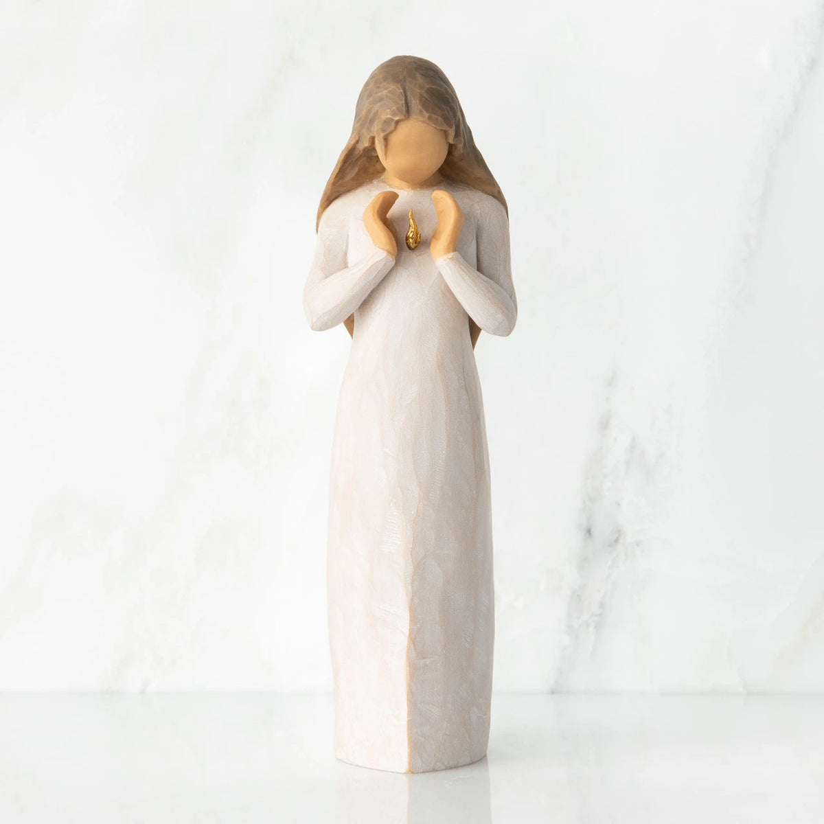 Front view, standing female figure in cream dress, hands surrounding small gold-leaf flame on chest
