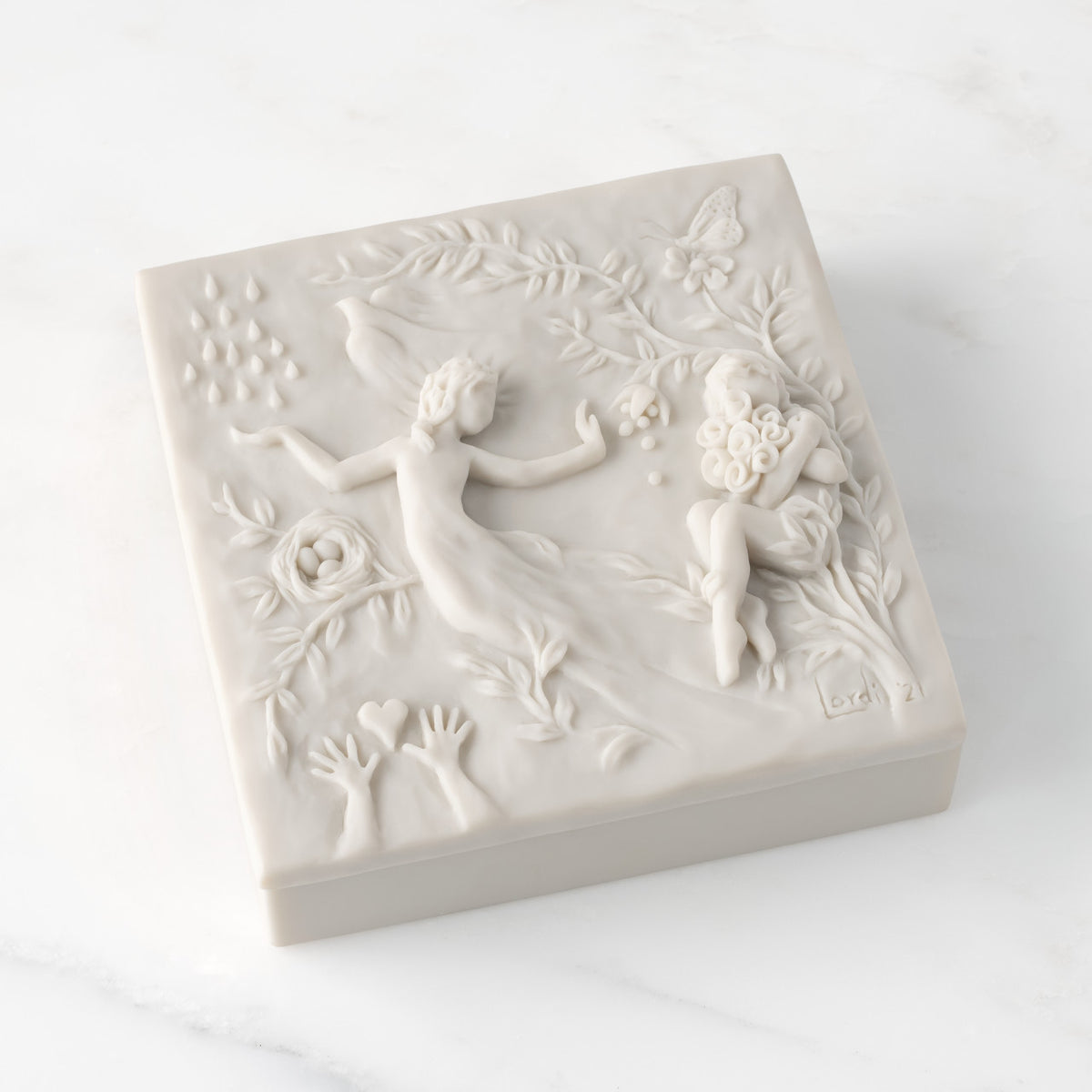 Closed white resin box; lid carved with figural and organic imagery
