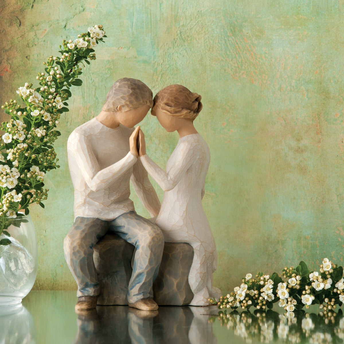 Willow Tree Around You, 6.5”h hand-painted figure of couple seated across from each other, heads and hands together, both in neutral clothing, in front of mossy green painting