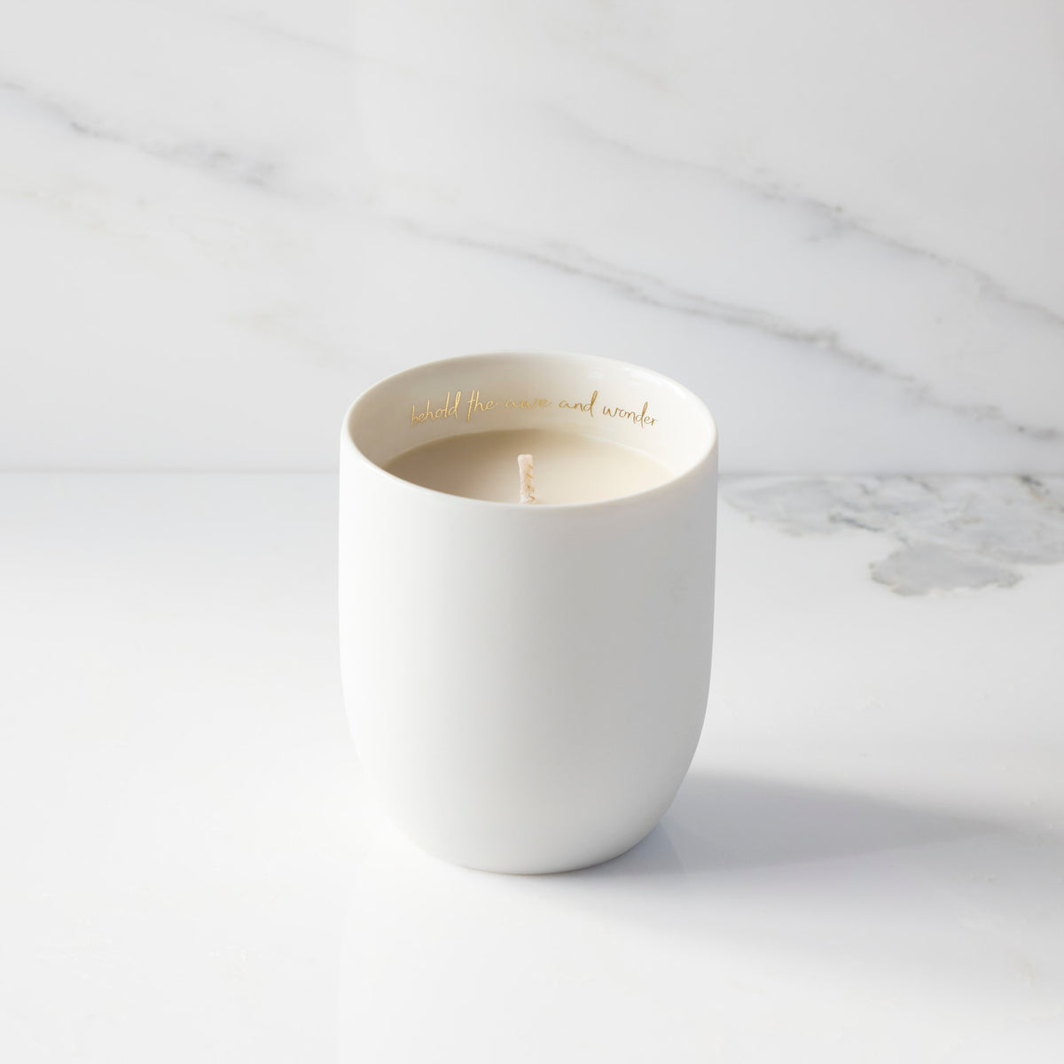 Filled scented candle with unglazed off-white tapered cylinder vessel, sentiment written in gold inside rim, plant-based wax blend, all-cotton wick.