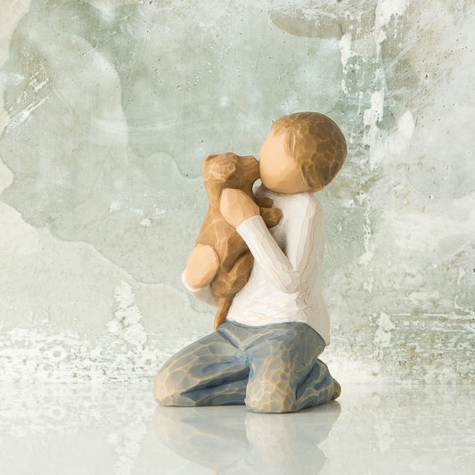 Willow Tree Kindness (boy), 3”h hand-painted resin figure of kneeling boy in neutral clothes, holding golden dog in arms, in front of gray painting
