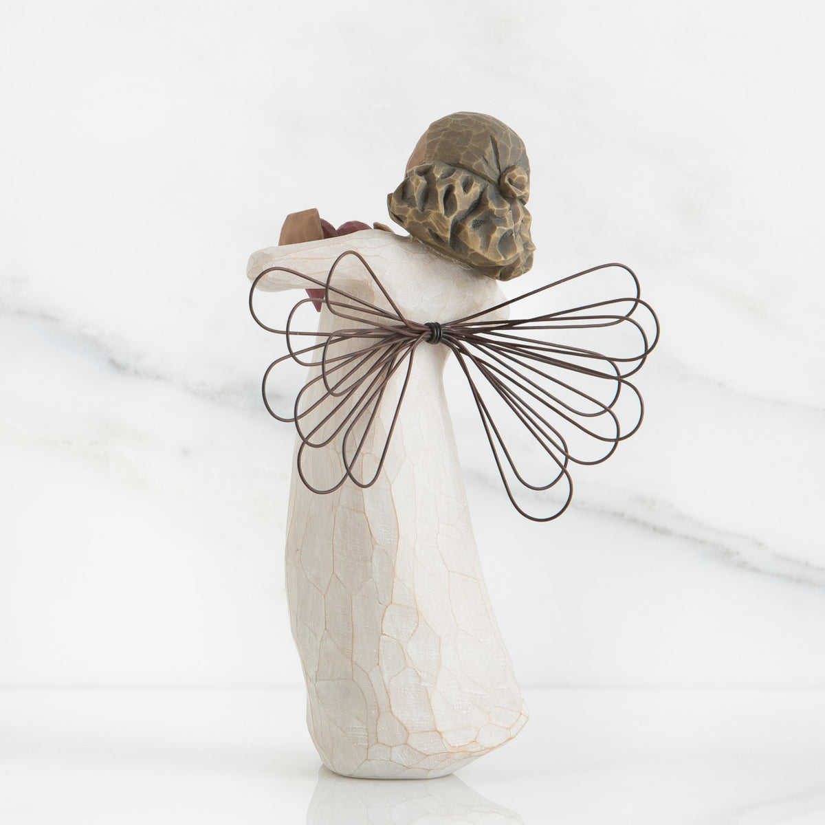 Back view of brunette angel figurine with brown wire wings standing up
