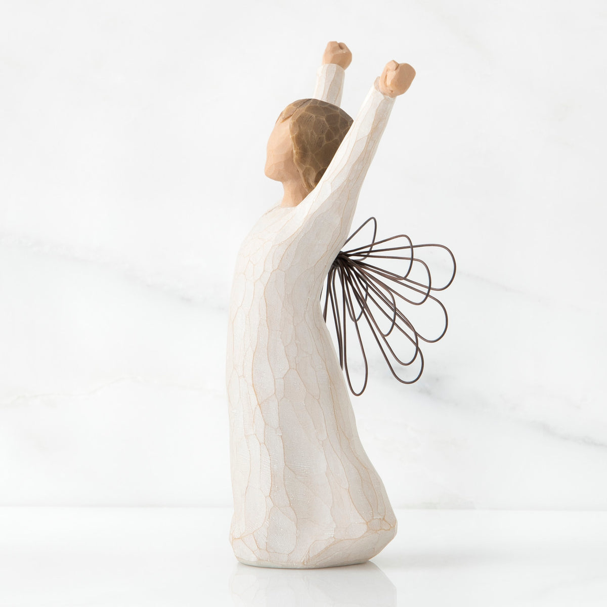 Side view of brunette girl figurine in white dress holding arms up with brown wire wings