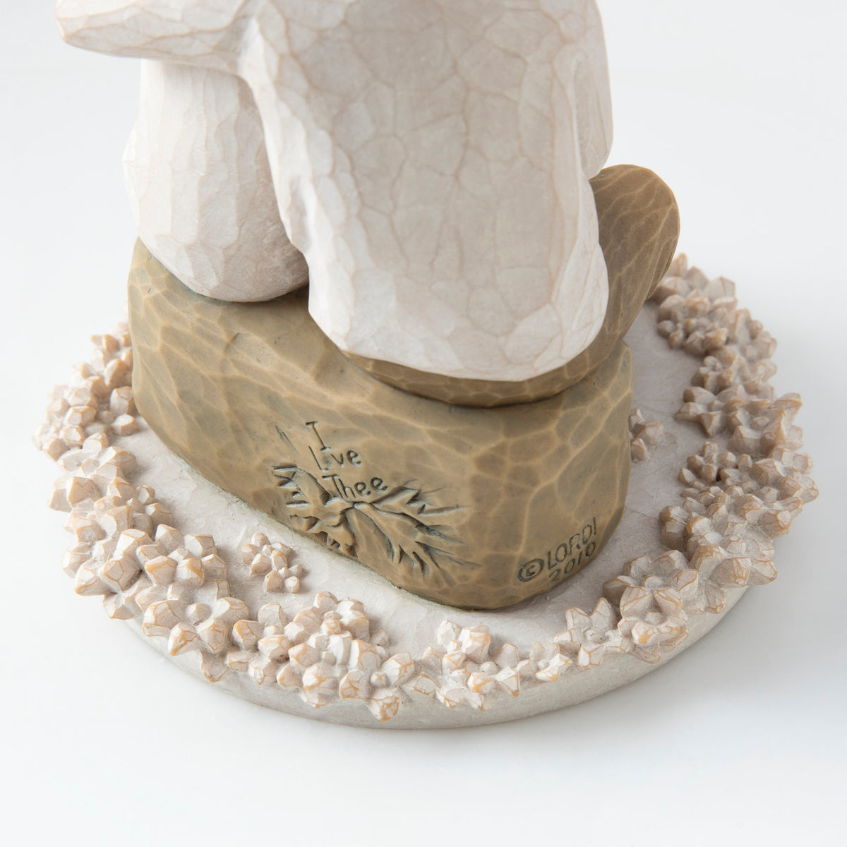 Close view of round white plaque with golden rock on top