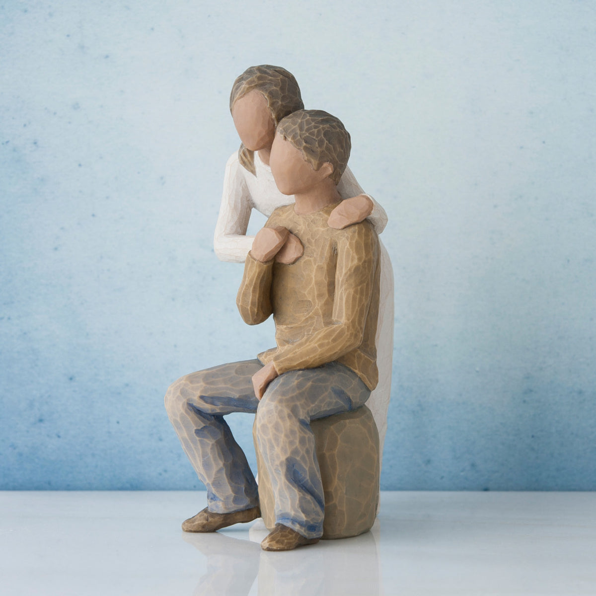 Man and woman figurine - man is in brown sitting down, woman is in white standing over him