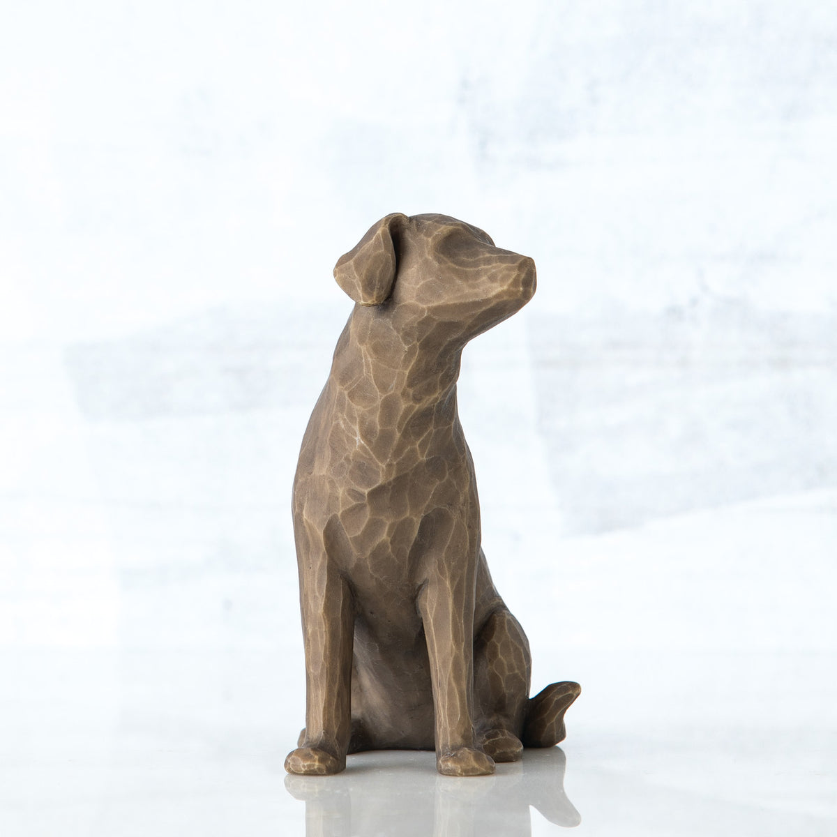 Dark grey sitting down dog figurine looking to the side