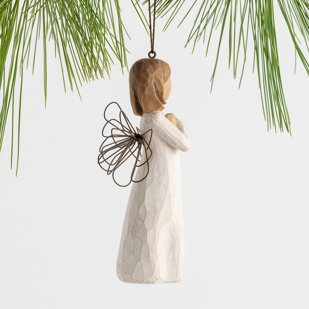 Side view figure in cream dress with wire wings and arms crossed in front of chest, ornament loop fixed to figure's head