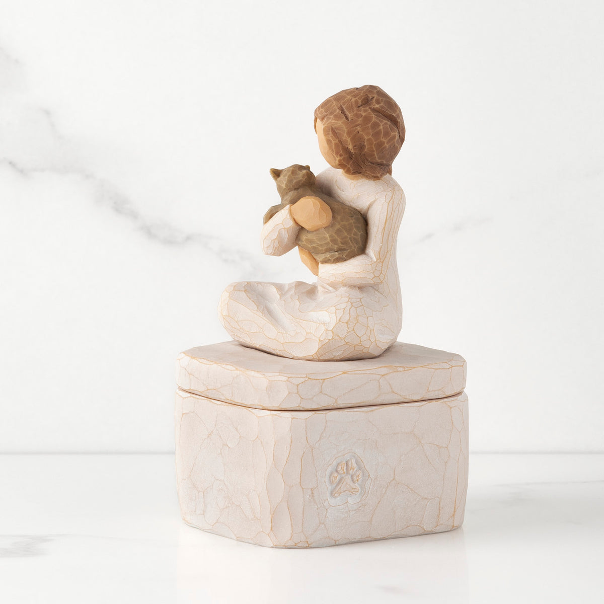 Cream square resin box, 3-D figure of seated girl holding cat on lid, paw print carving on side of box