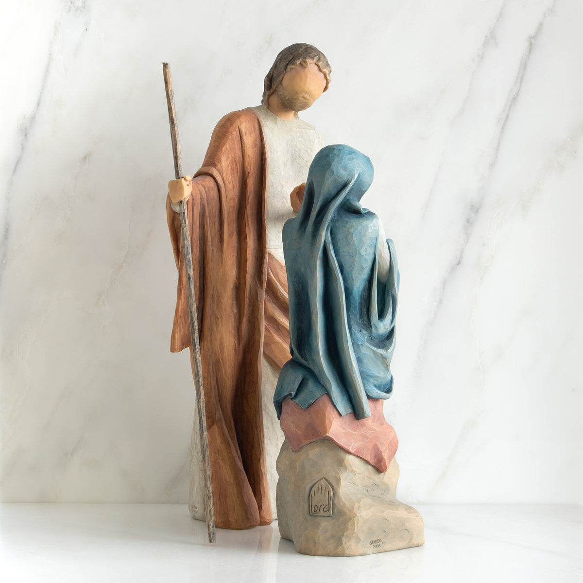 Nativity scene figurines facing forward - man is wearing brown, woman is wearing blue