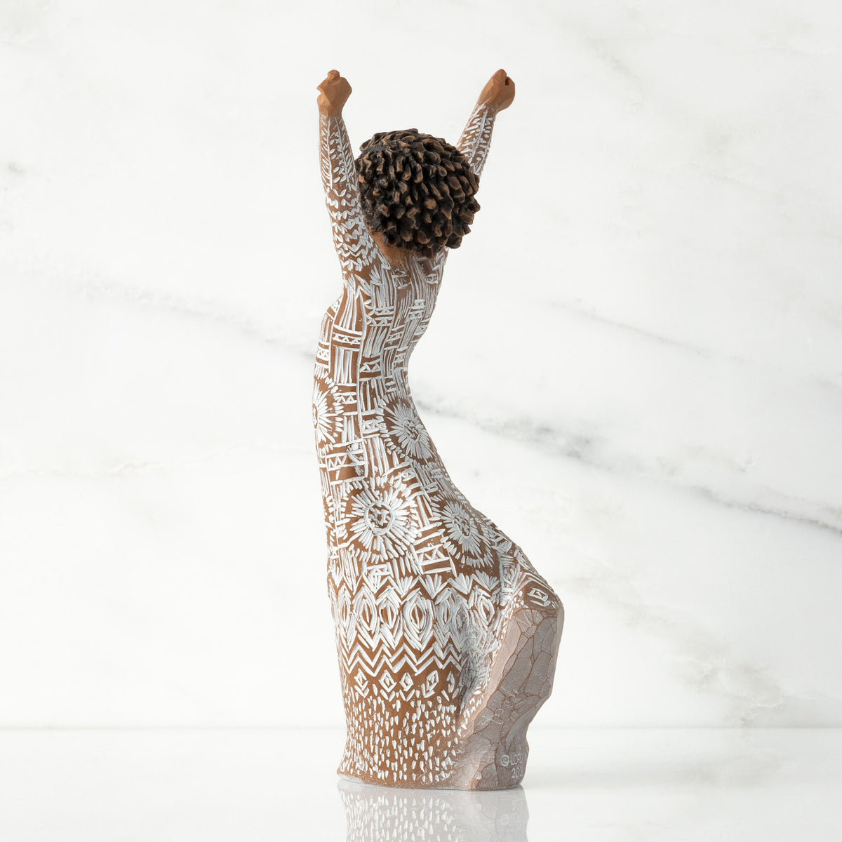 Left back of figure, with arms raised overhead, dress etched with African textile patterns