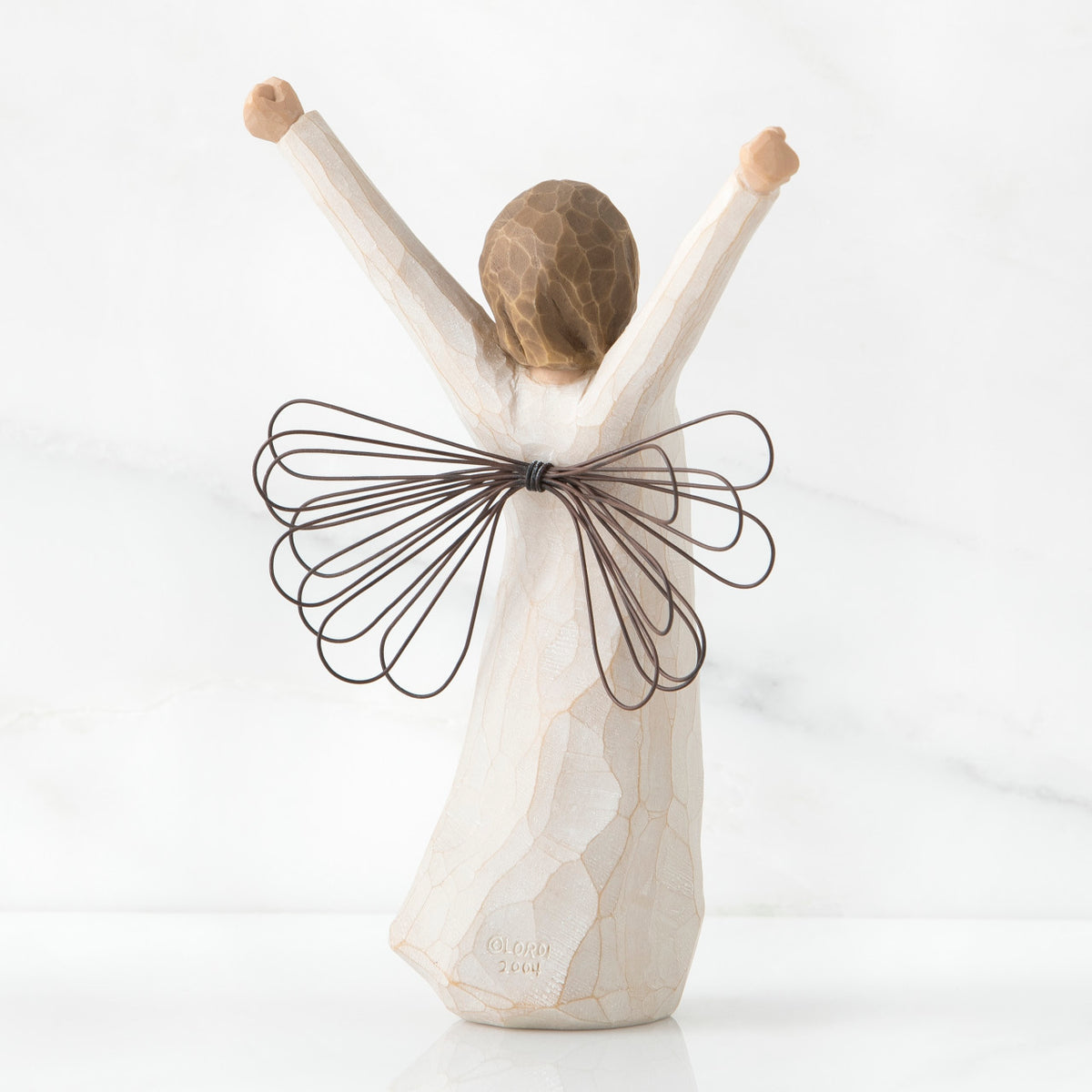 Back view of brunette angel figurine in white dress with brown wire wings