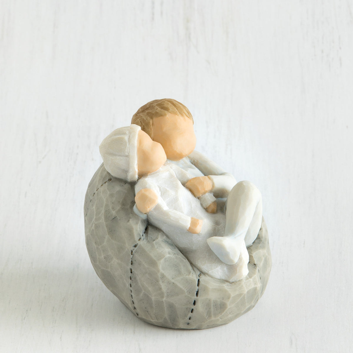 Close view of grey bean bag with two siblings hugging one another on it