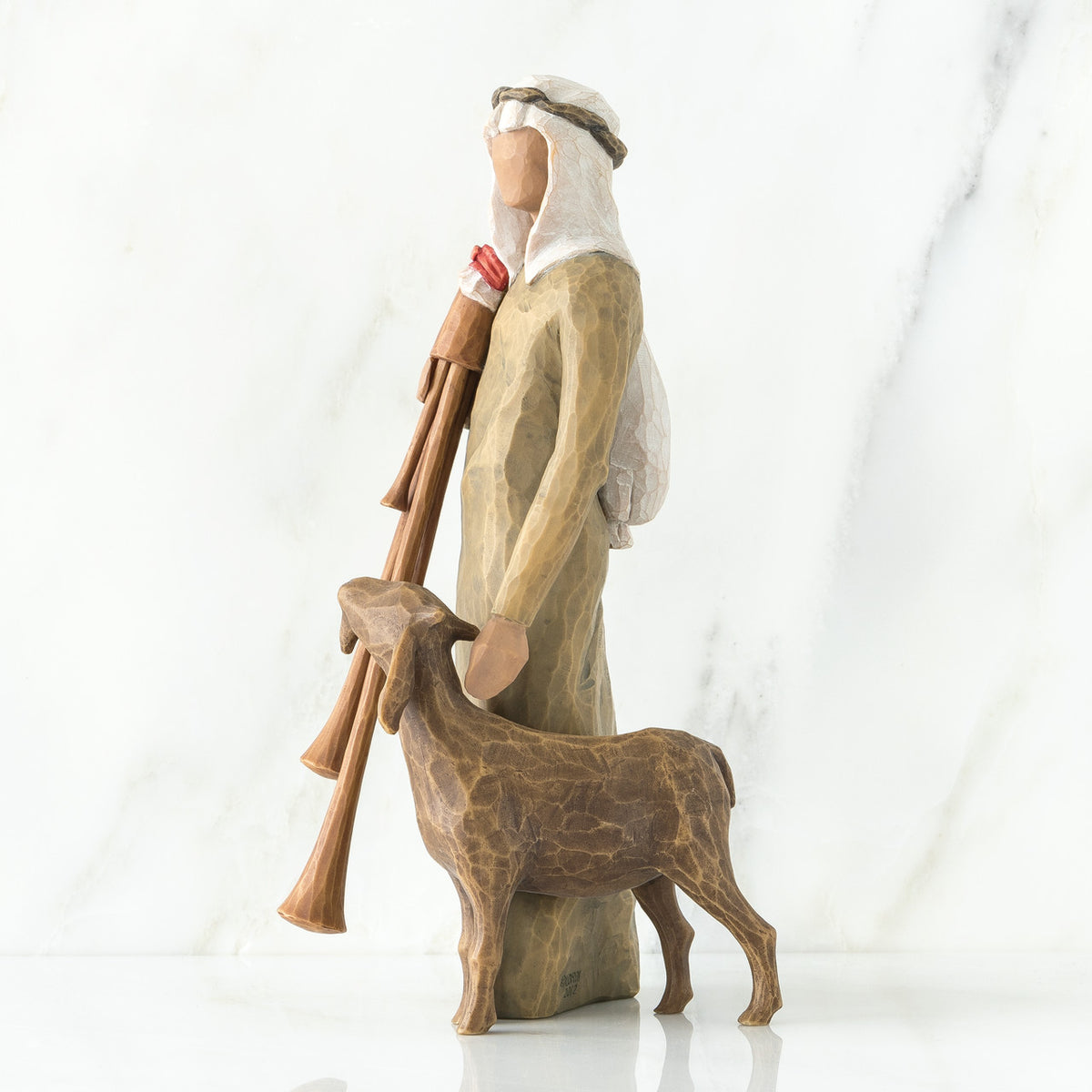 Wiseman figurine in brown next to sheep figurine