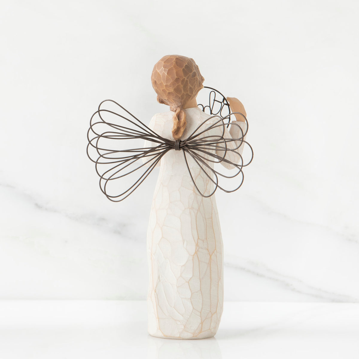 Back view of angel with tied back brown hair, holding up a circular wire sign that says "thank you"