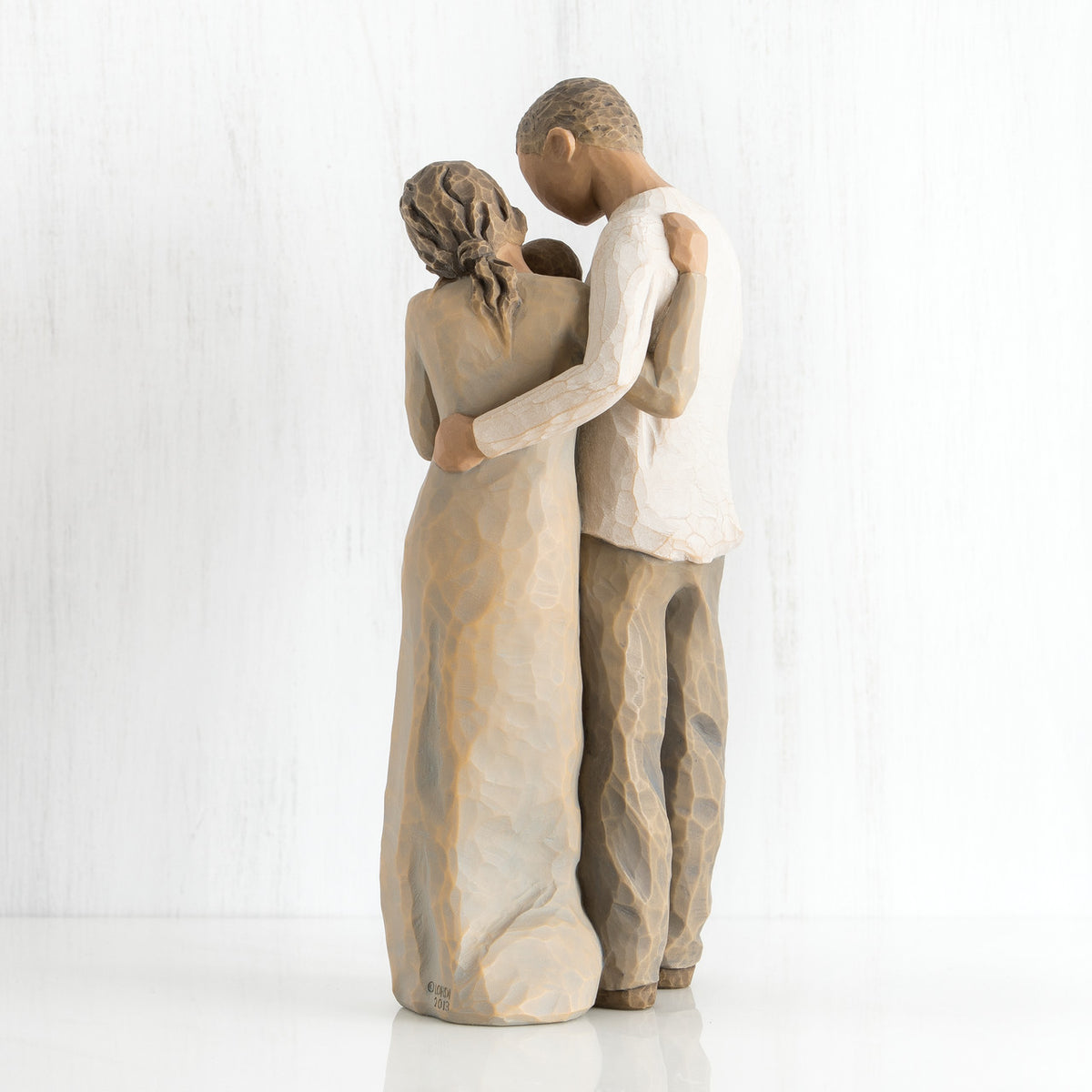 Back view of man and woman figurines hugging one another