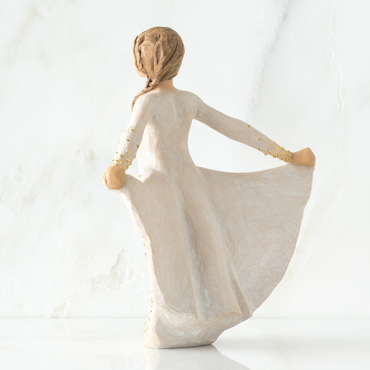 Back view of brunette woman in white dress holding up her dress