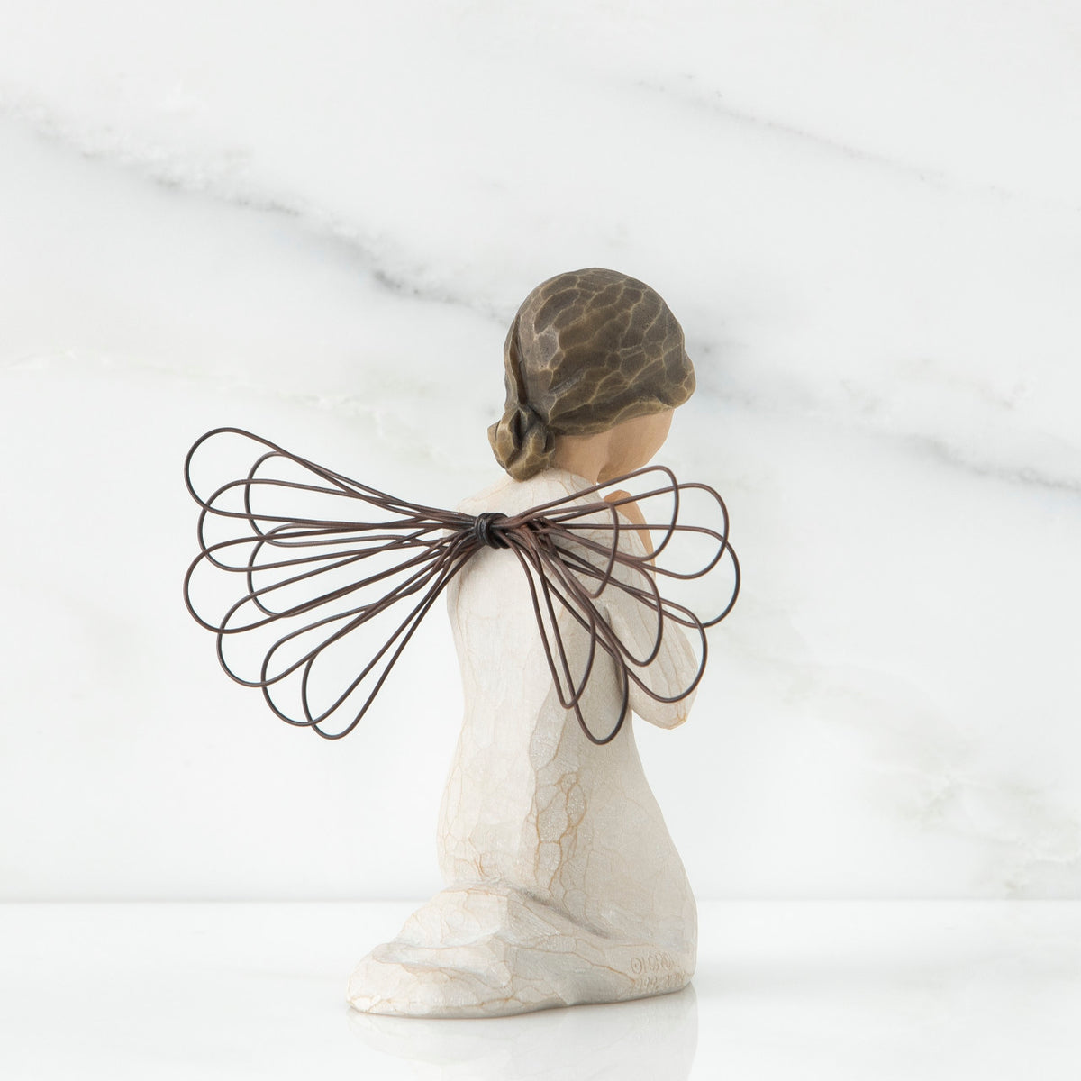 Small girl figurine in white with brown wings kneeling with hands folded