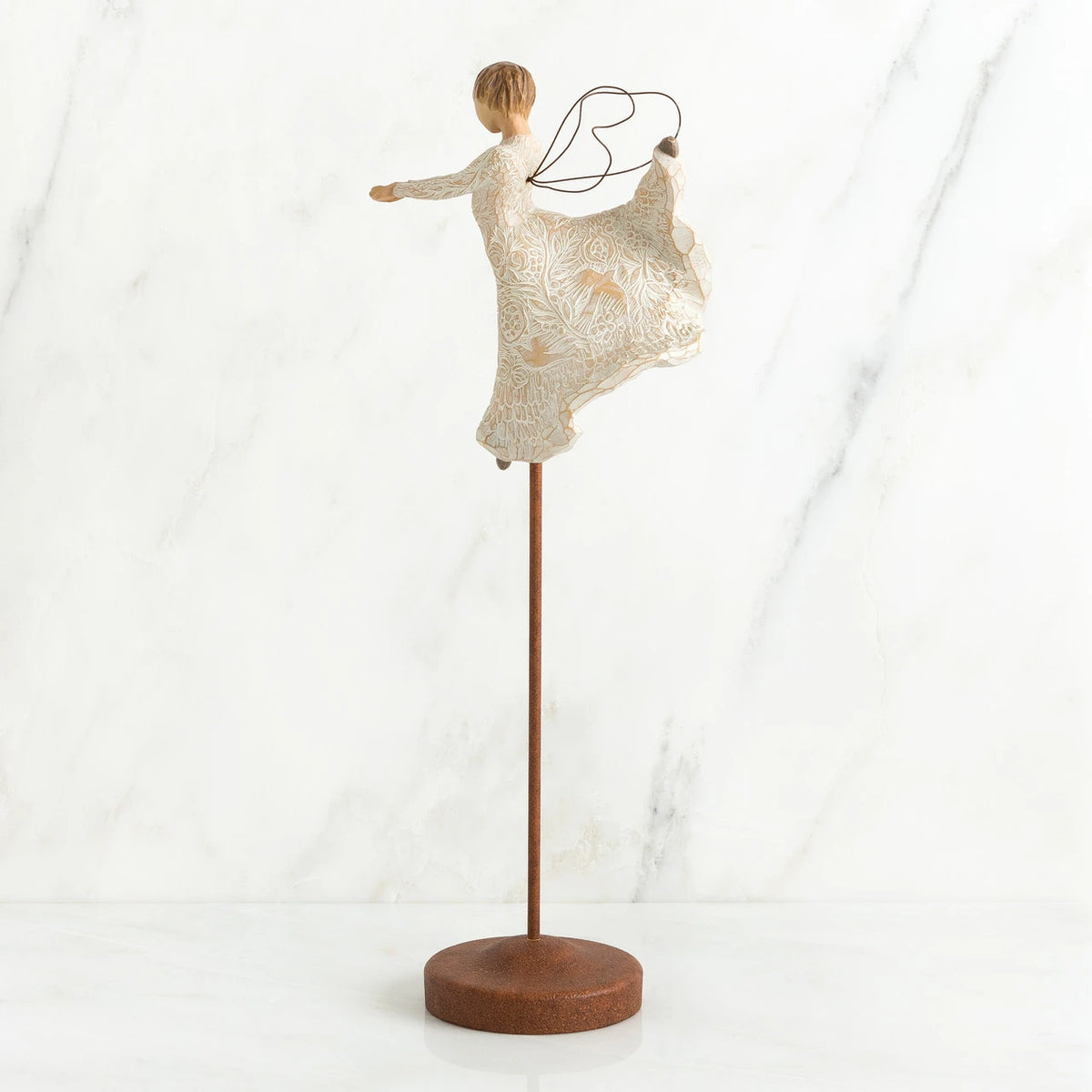 Brunette angel figurine in white dress on wooden stand with her arms out