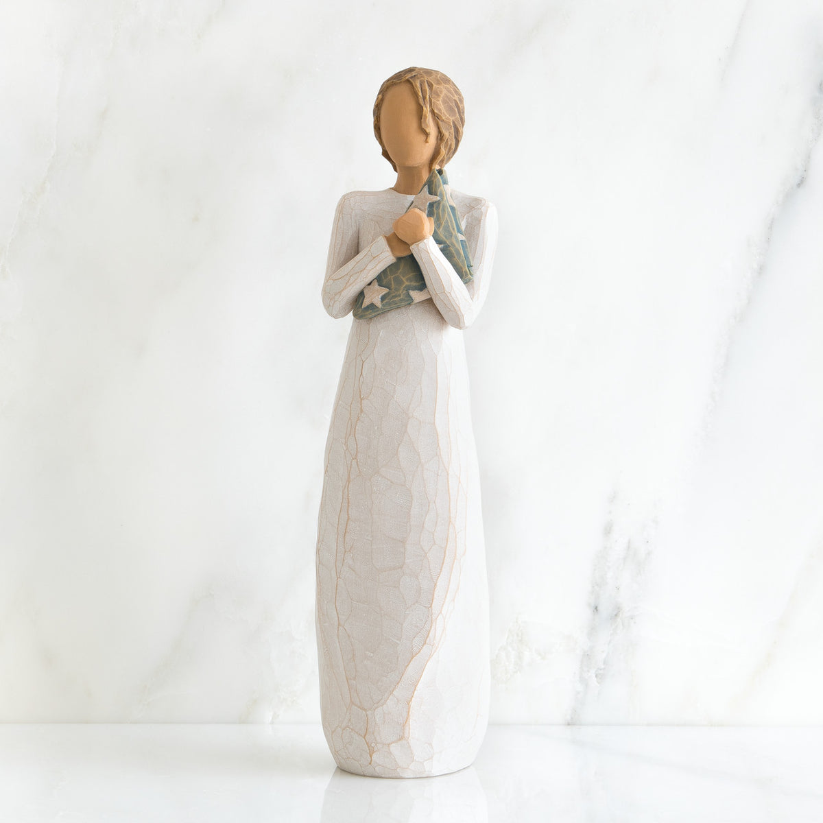 Faceless woman figurine standing facing forward wearing white dress holding star print napkin