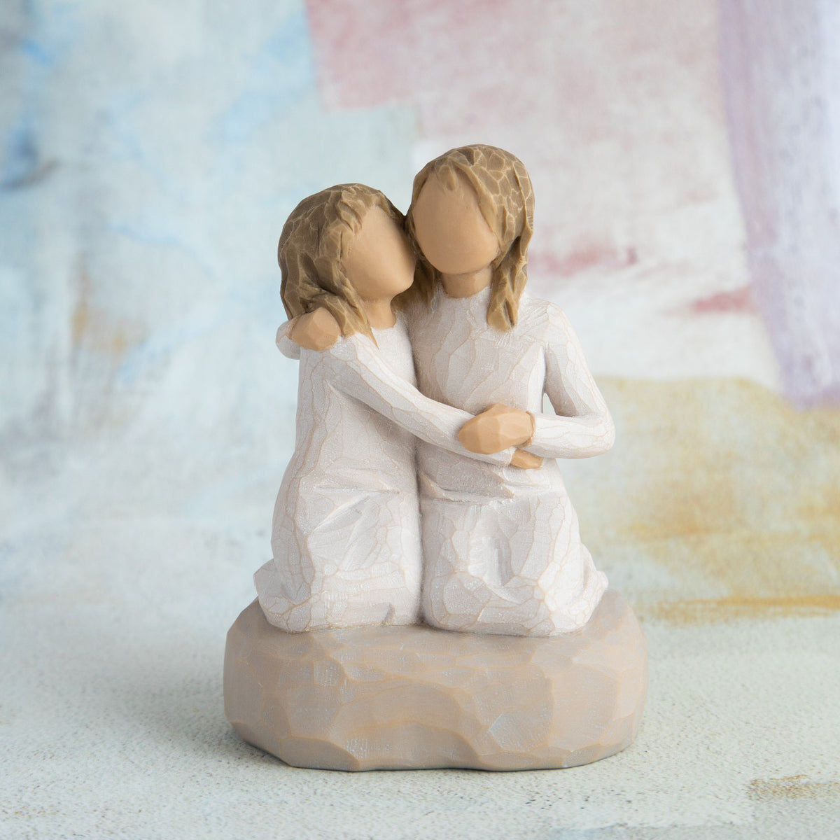 Willow Tree Sister mine, 4”h hand-painted resin figure of two girls in cream dresses, kneeling with arms around each other, in front of pastel painting