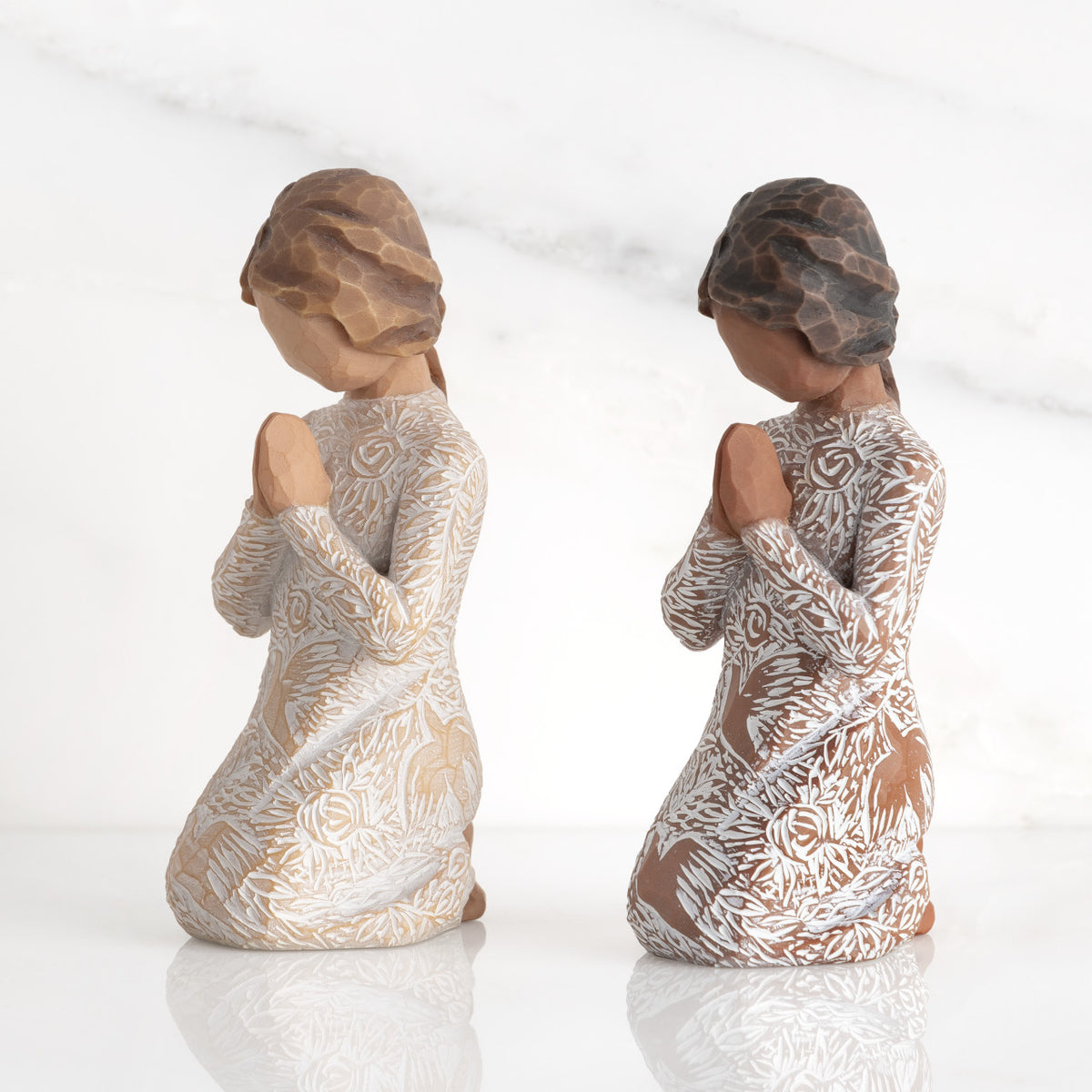 Lighter &amp; Darker skin Kneeling figures, hands in position of prayer or meditation in cream dress carved with icons of nature, lighter and darker skin versions
