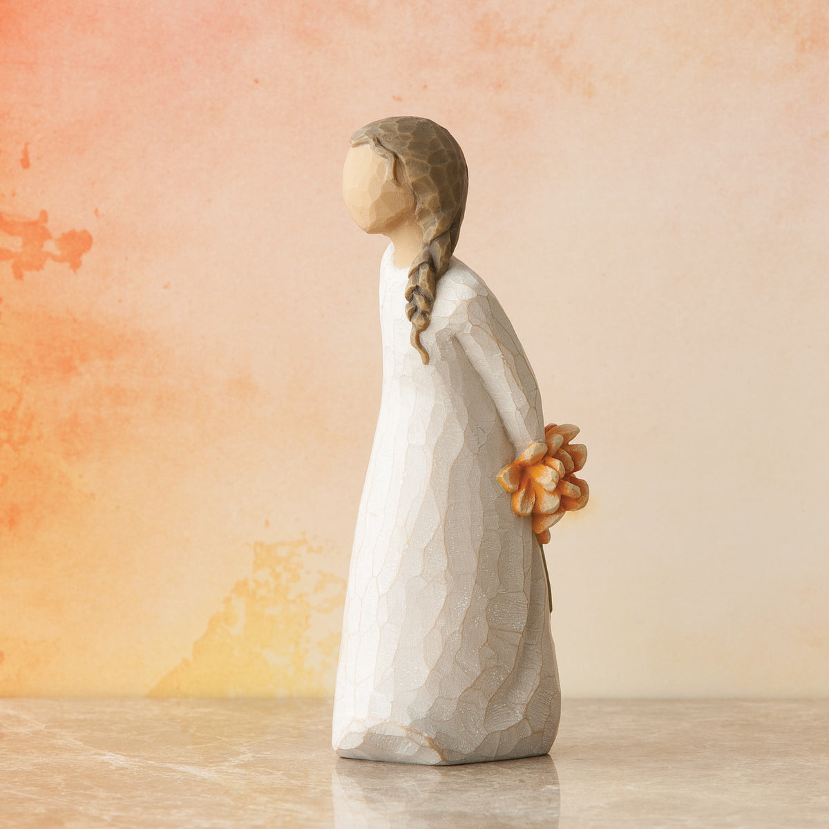 Willow Tree For You, 5”h hand-painted standing resin figure in cream dress, holding bouquet of orange flowers behind back, in front of pale orange painting