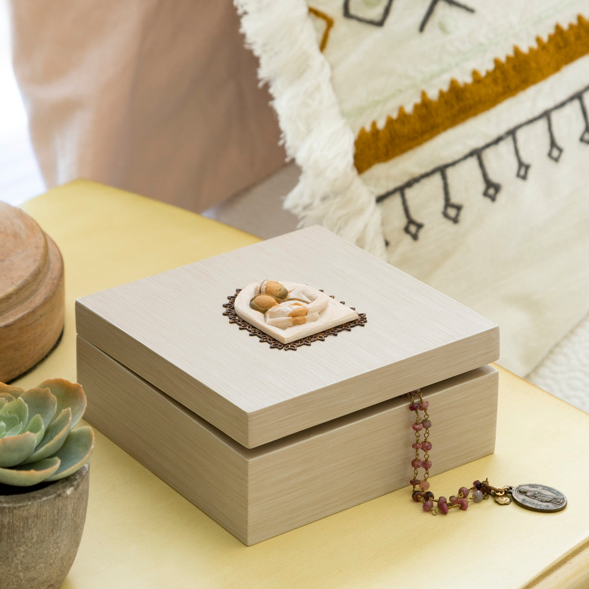 Willow Tree Holy Family Memory Box, 4.75”sq x 2.5”h hand-painted cream wood box, closed hinged lid has bas-relief metal-edged carving of the Holy Family affixed to top and ‘A child is born’ sentiment inside