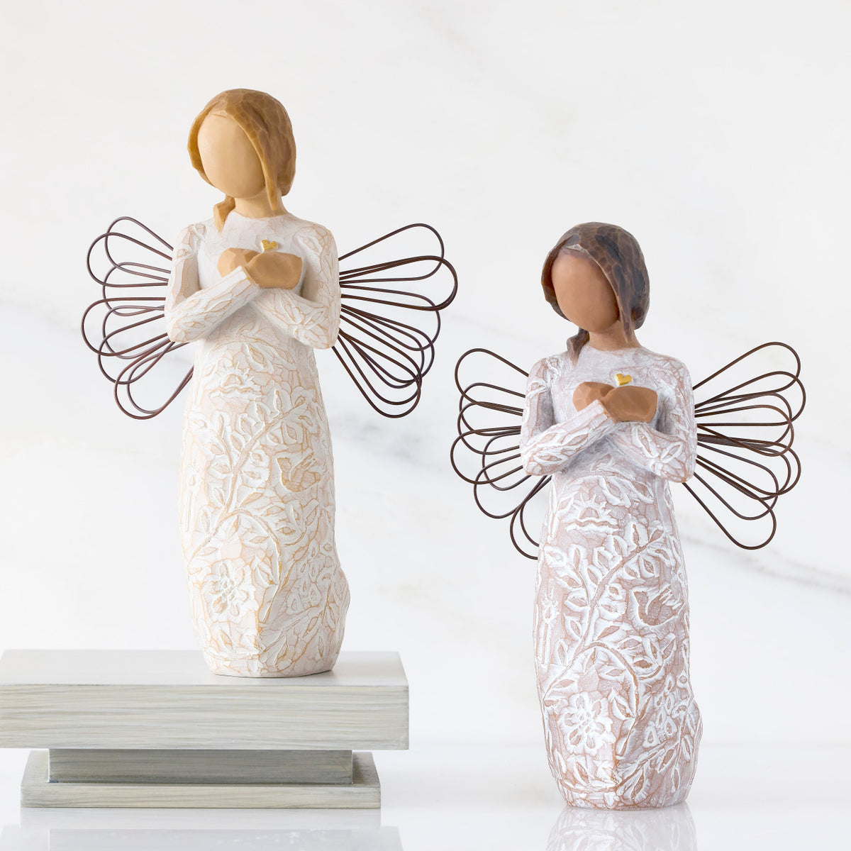 Lighter &amp; Darker skin versions of angel with wire wings, arms crossed over gold heart, carved with symbols of remembrance