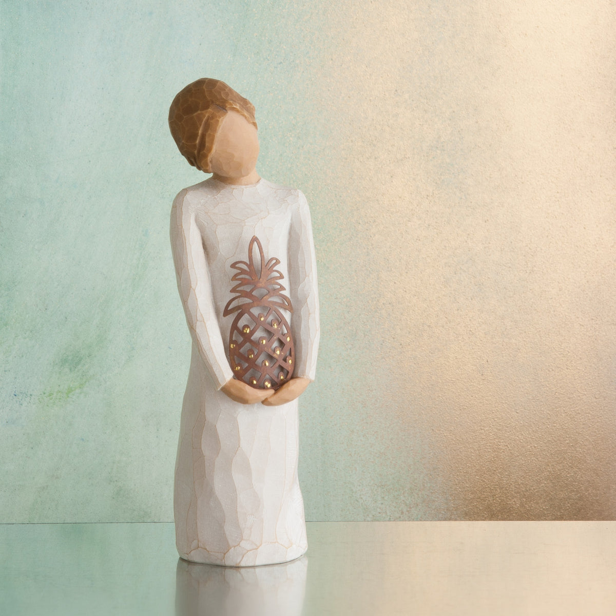 Willow Tree Gracious, 5.5" hand-painted standing resin figure in cream dress, holding pierced-metal pineapple, in front of minty green painting