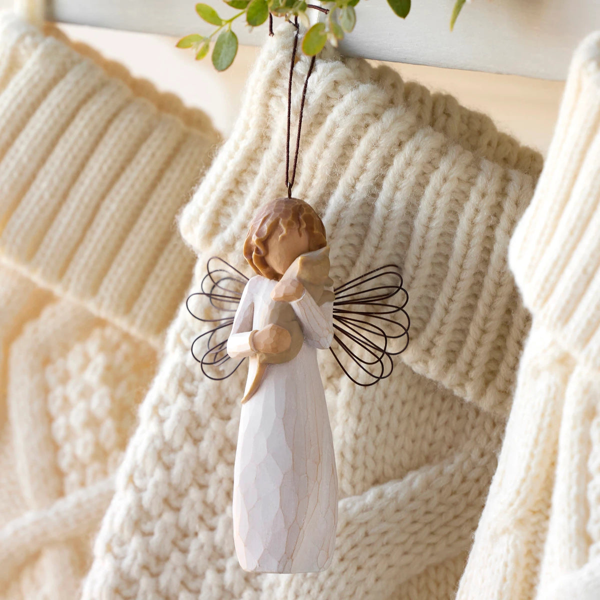 Willow Tree With affection Ornament, 4.5”h hand-painted resin figure in cream dress with wire wings, holding gray cat, brown elastic cord, hanging with cream knitted Christmas stockings