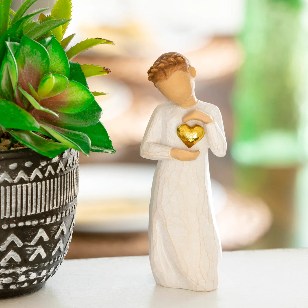 Willow Tree Keepsake, 5.5”h hand-painted standing resin figure in cream dress, holding gold-leaf heart against chest, in front of light green painting