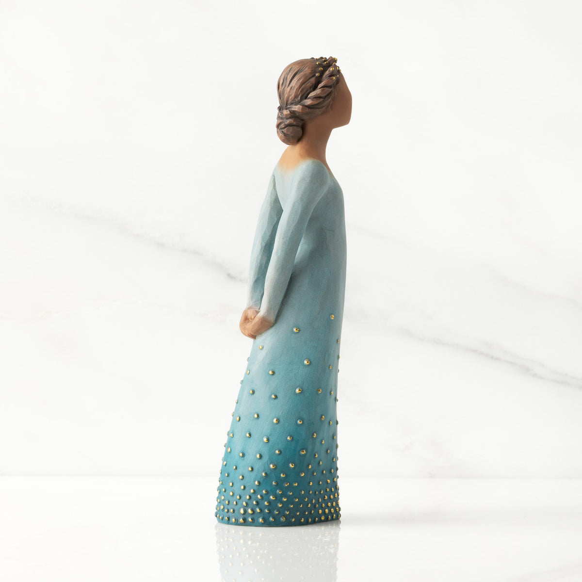 Right profile: Darker-skin figure, arms clasped behind back, hair and deep blue ombré garment dotted with gold leaf