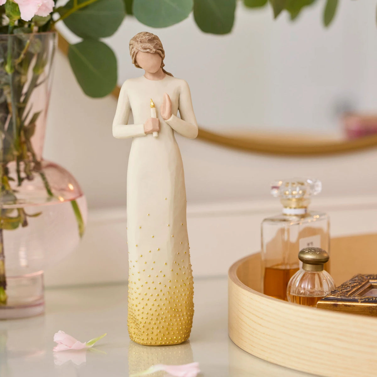 Willow Tree Vigil, 10”h hand-painted standing resin figure in cream dress, holding candleholder with gold candle, skirt embellished with gold-leaf, on dressing table