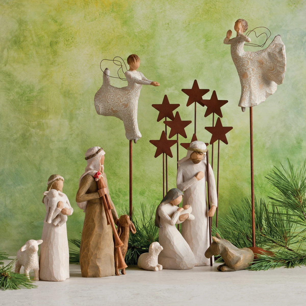Several wiseman figurines dressed in white around lamb figurines with green background