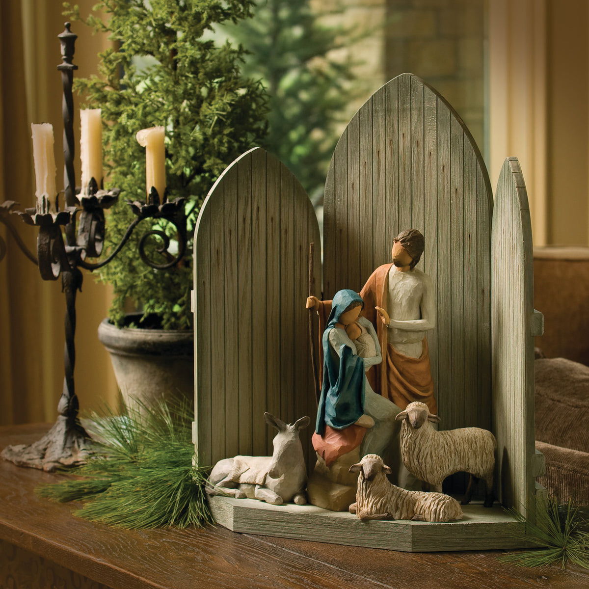 Side view of dark grey barn tri-fold on table with mary and joesph figurines in the center with two white sheep and donkey figurine under them