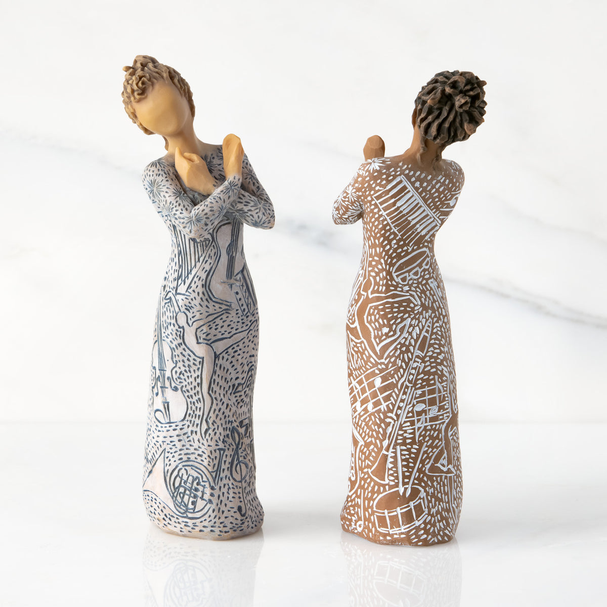 Two versions: figures with carved musical instruments & dancing forms. Front of Lighter-skin piece, back of Darker-skin piece