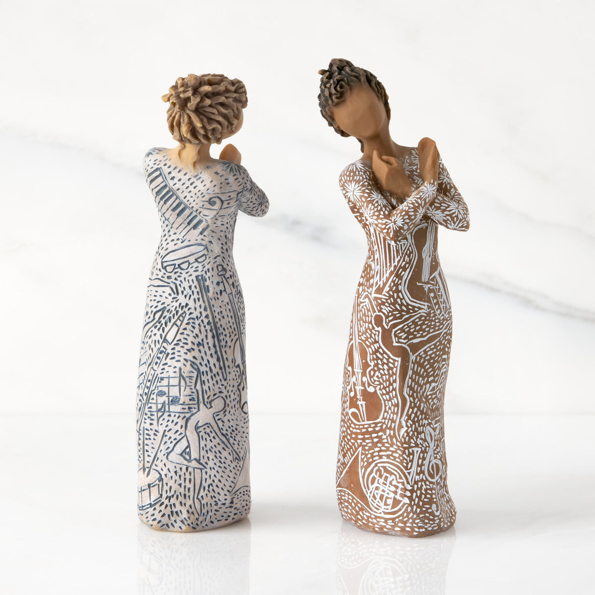 Two versions of figures with carved musical instruments & dancing form. Back of Lighter-skin piece, front of Darker-skin piece