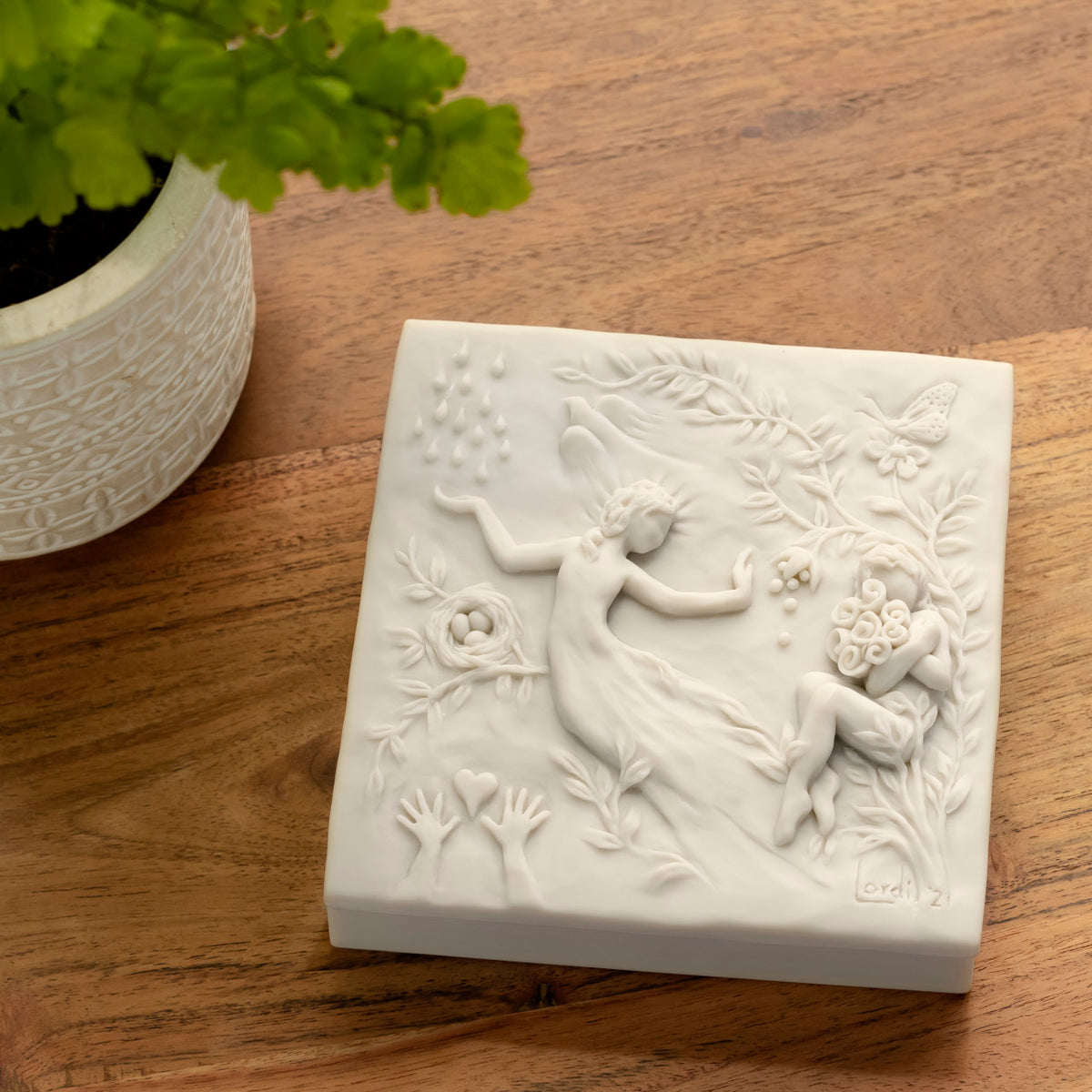 Willow Tree A Healing Wish Keepsake Box, 5"sq x 1.75"H hand-painted off-white resin box, detatched lid carved with organic/figural symbols, sentiment inside lid and velvety finish inside base, on wood table